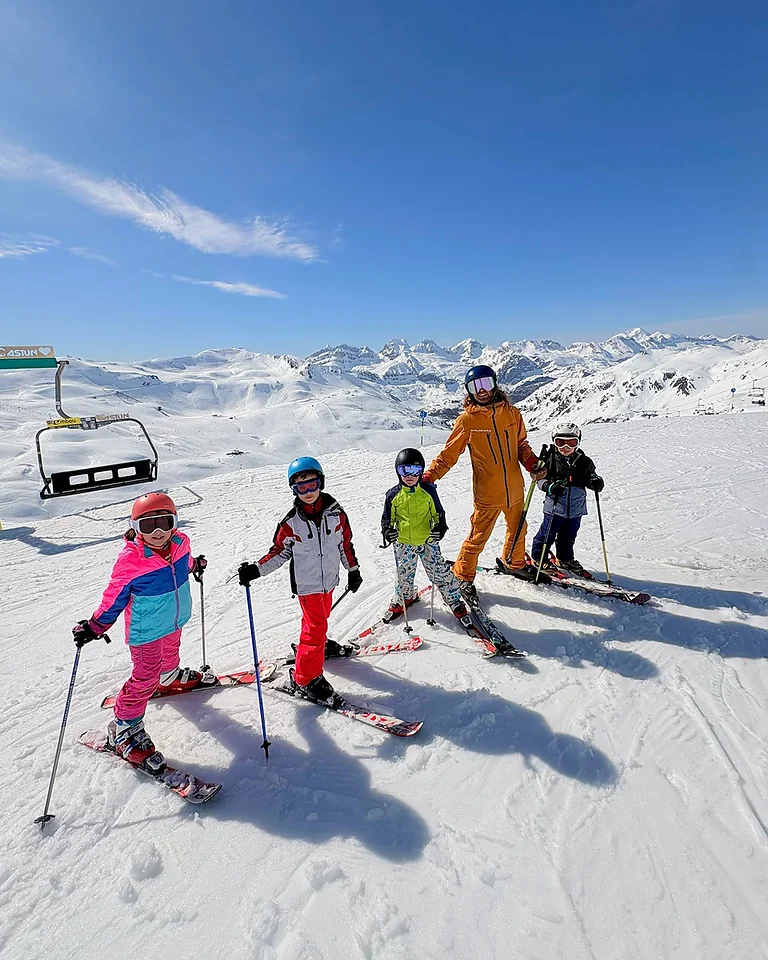 Cuatro niños con un profesor de Malacara en una pista de esquí.