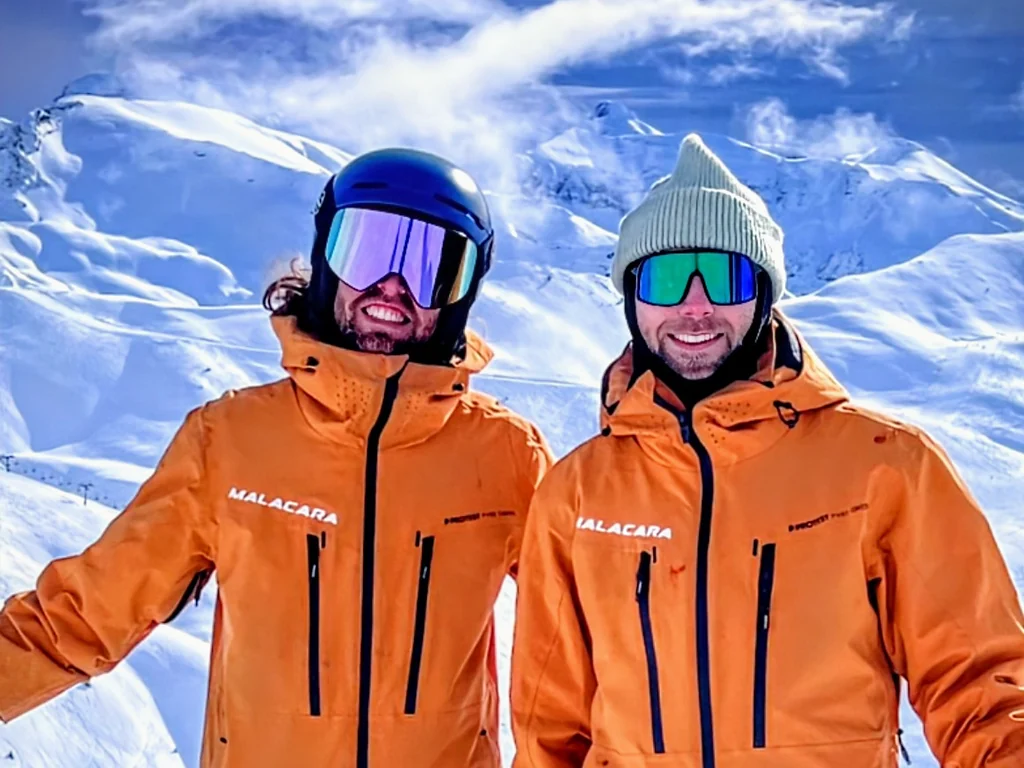 Dos profesores de Malacara con uniforme naranja en la montaña.